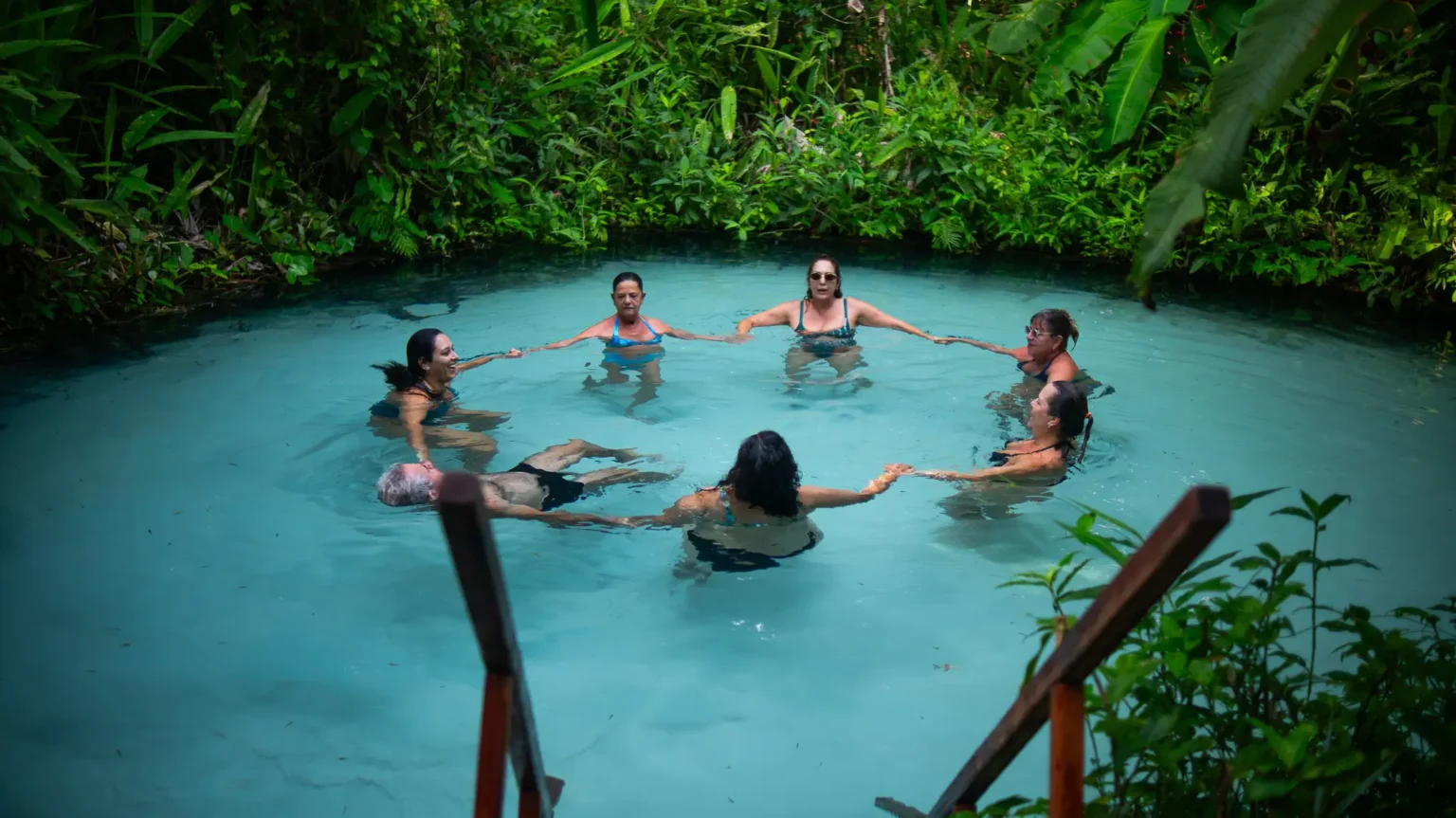 Viajantes flutuando em um fervedouro de água azul no Jalapão